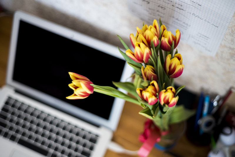 Bunch of flowers next to a laptop