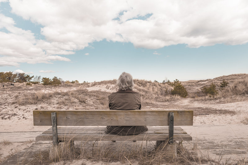 Person sat on a bench at the beach