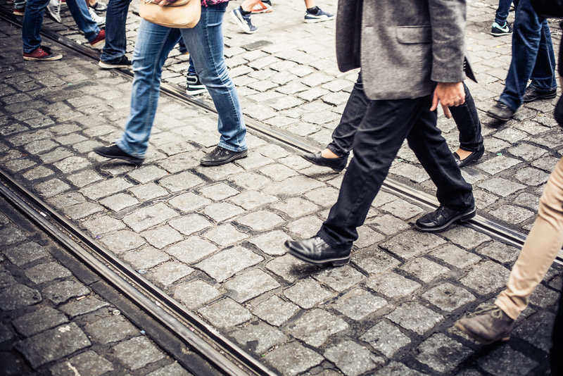 People crossing a cobblestone road