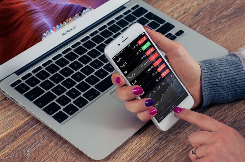 Woman looking at stocks and shares on iPhone
