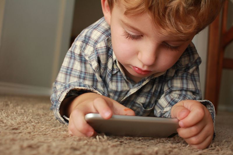 Child looking at iPhone to learn about money
