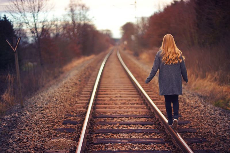 Young girl walking on railway