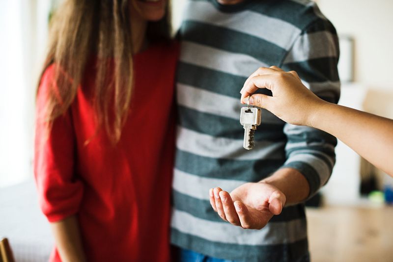 Woman handing over keys for house bought with help to buy isa