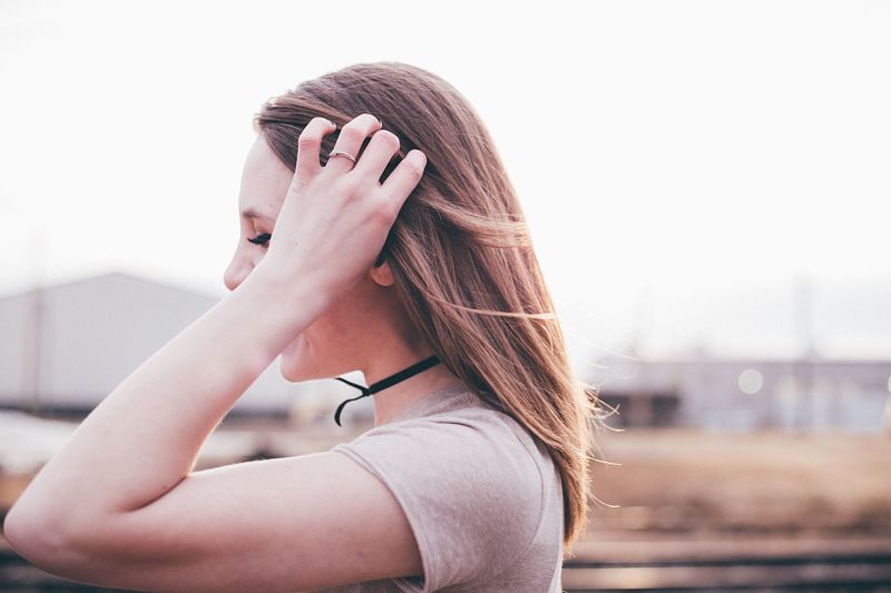 Girl brushing hair out of face