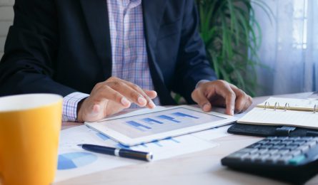 man with ipad and notes calculating isa allowance for tac year 2022-23