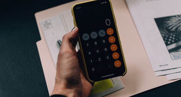 person using iphone calculator app for world financial planning day