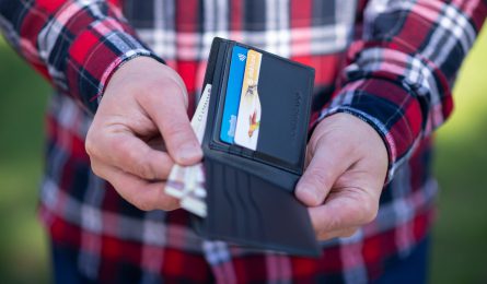 Hands opening a wallet with money and cards inside trying to learn how to stop spending money