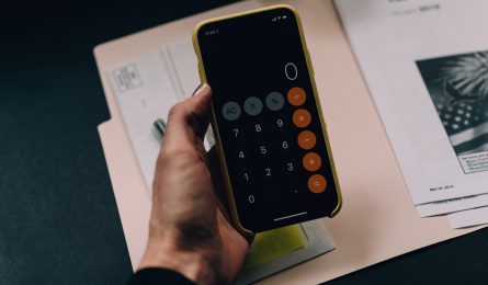 person using iphone calculator app to save