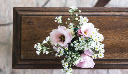 Coffin with flowers on top showing the cost of end of life expenses
