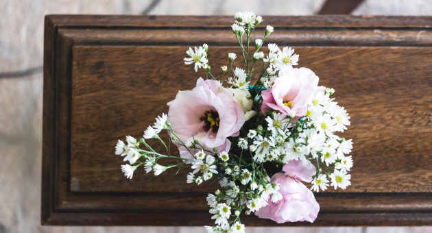 Coffin with flowers on top showing the cost of end of life expenses